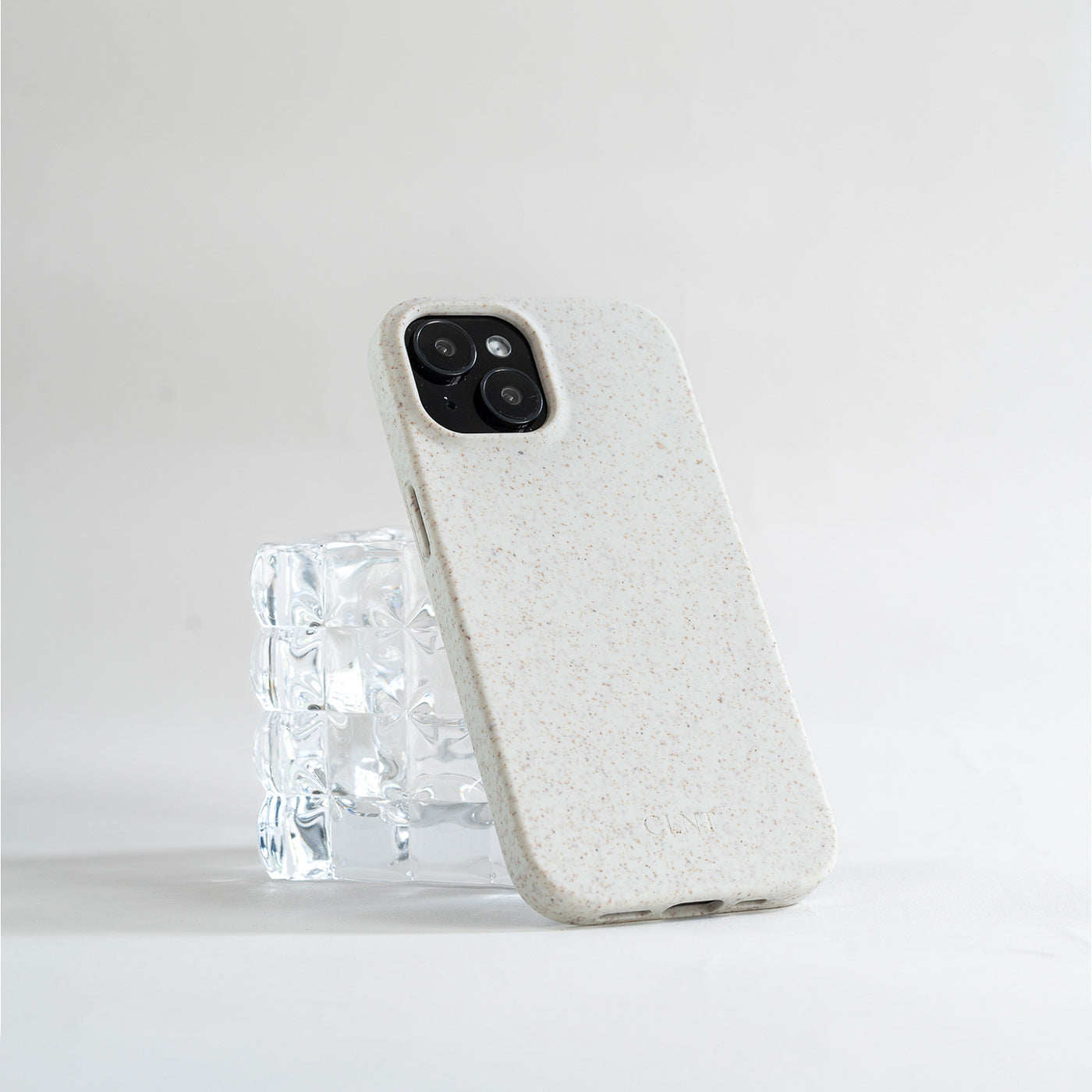 Grått iphone deksel fra CLNT som hviler på et glass
