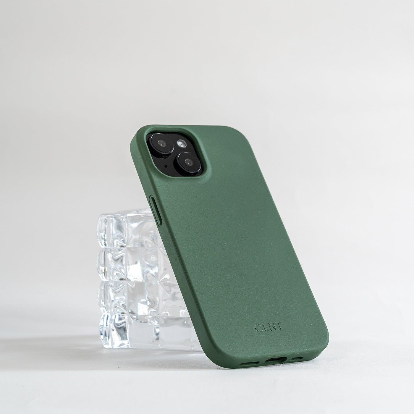 Grønt iPhone deksel fra CLNT som hviler på et glass