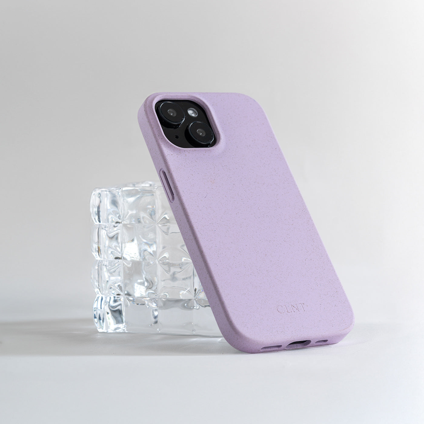 lilla iphone deksel fra CLNT som hviler på et glass