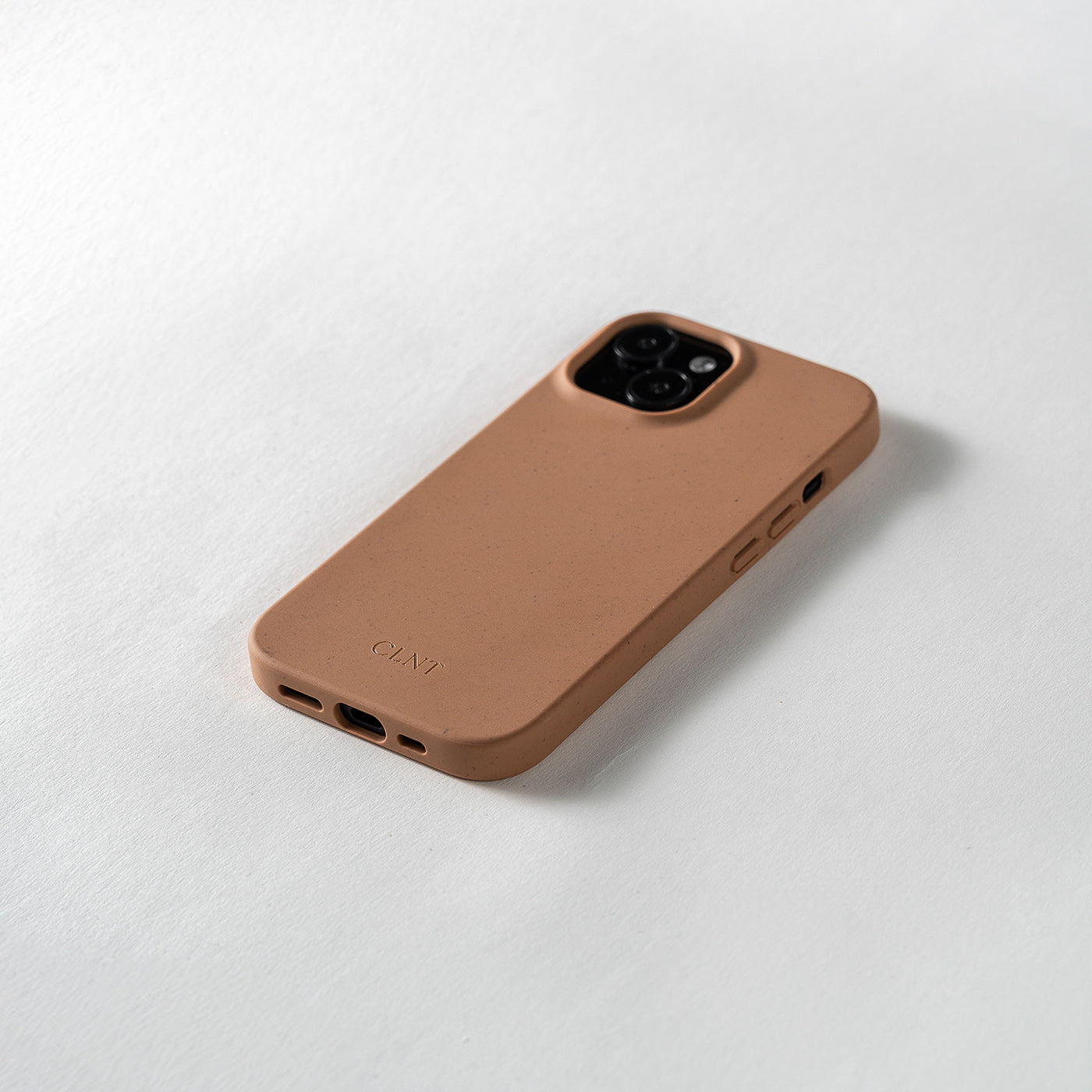 Nærbilde av rustfarget mobildeksel til iPhone fra CLNT i fotostudio.