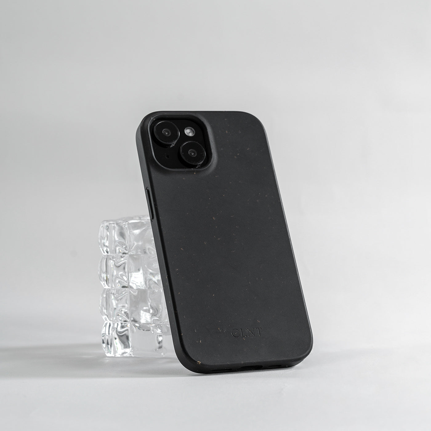 Svart iPhone deksel fra CLNT som hviler på et glass