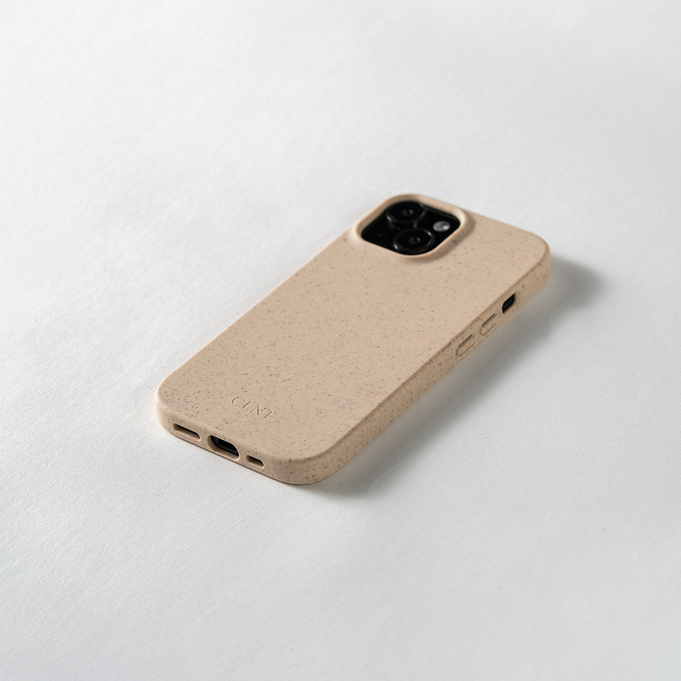Nærbilde av beige mobildeksel til iPhone fra CLNT i fotostudio. 